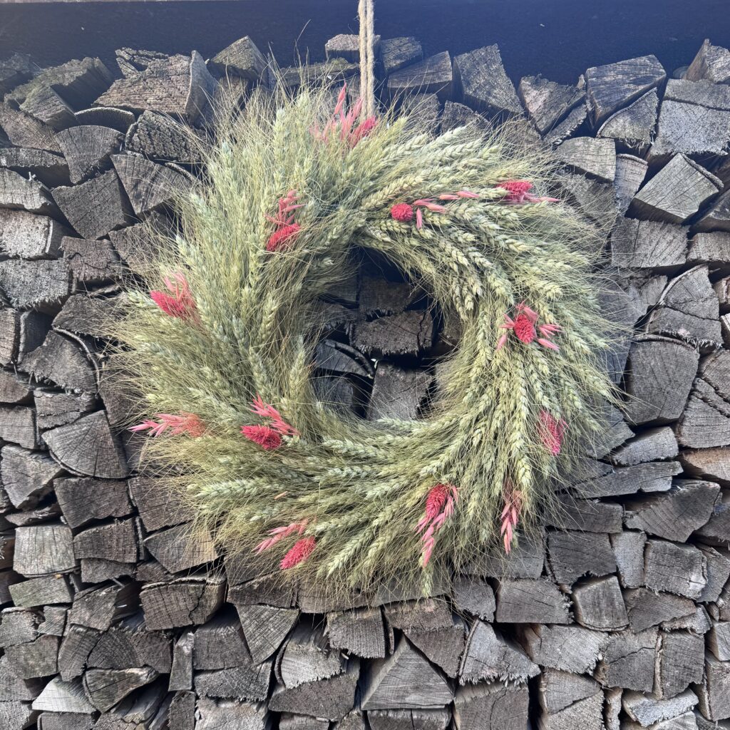 ommer-Kranz aus satten Kornähren, kombiniert mit feinen rosa Blüten und Gräsern. Diese Mischung macht den Kranz lebendig, frisch und modern