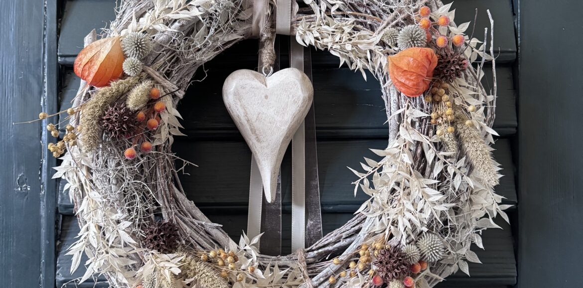 Handgemachter Herbst-Kranz aus weiss gekalkten Zweigen mit Naturmaterialien, Lampionblüten, Gräsern und Holzherz, dekoriert im Shabby-Chic-Stil.
